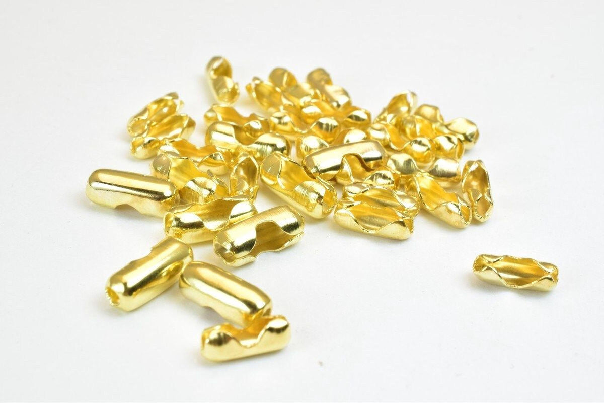 a pile of shiny, golden-colored metal pieces scattered on a white background.