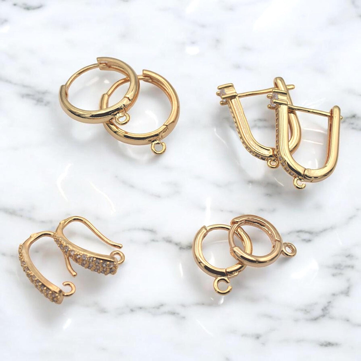 Gold hoop findings placed next to a metric ruler to show precise millimeter sizing for jewelry designers.