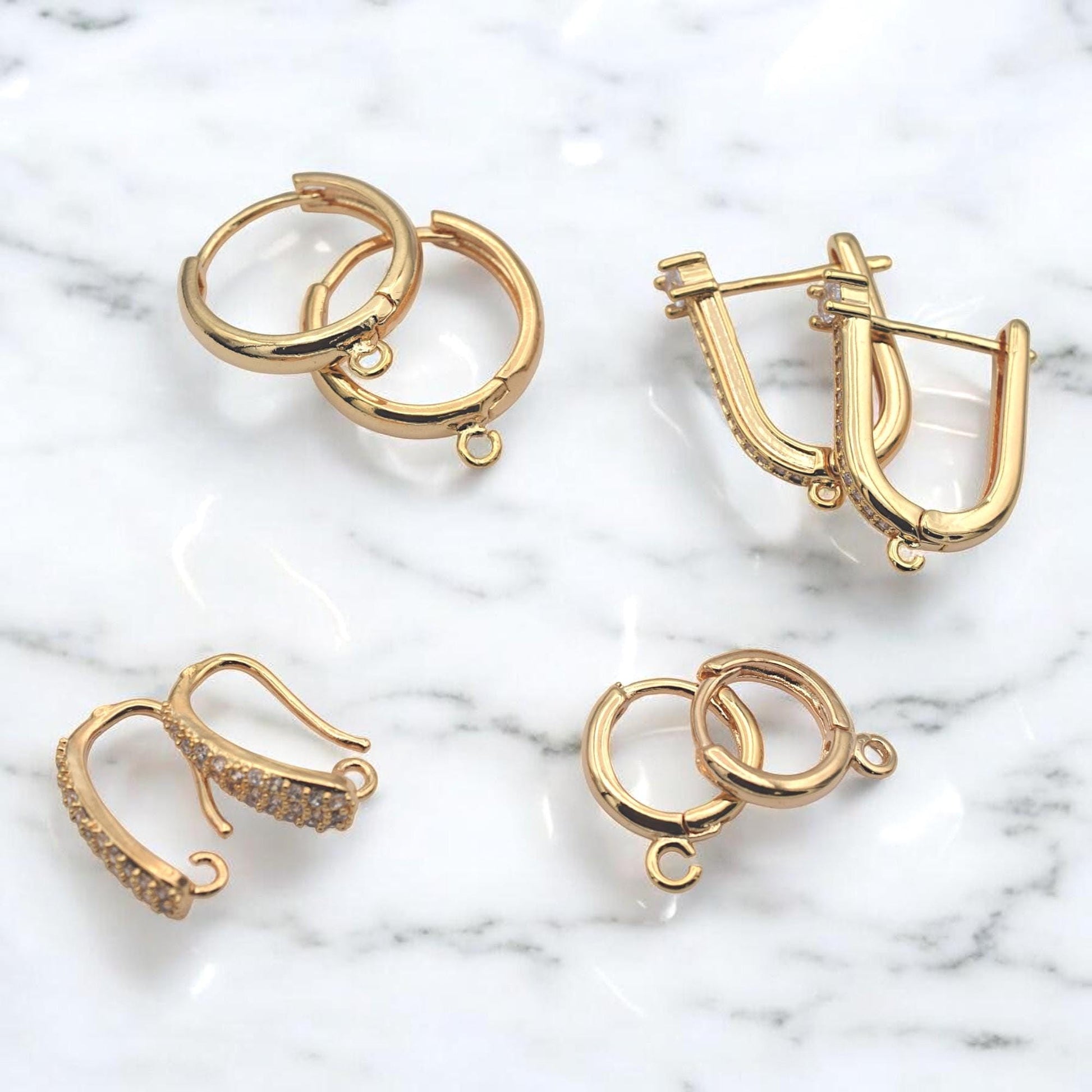 Gold hoop findings placed next to a metric ruler to show precise millimeter sizing for jewelry designers.