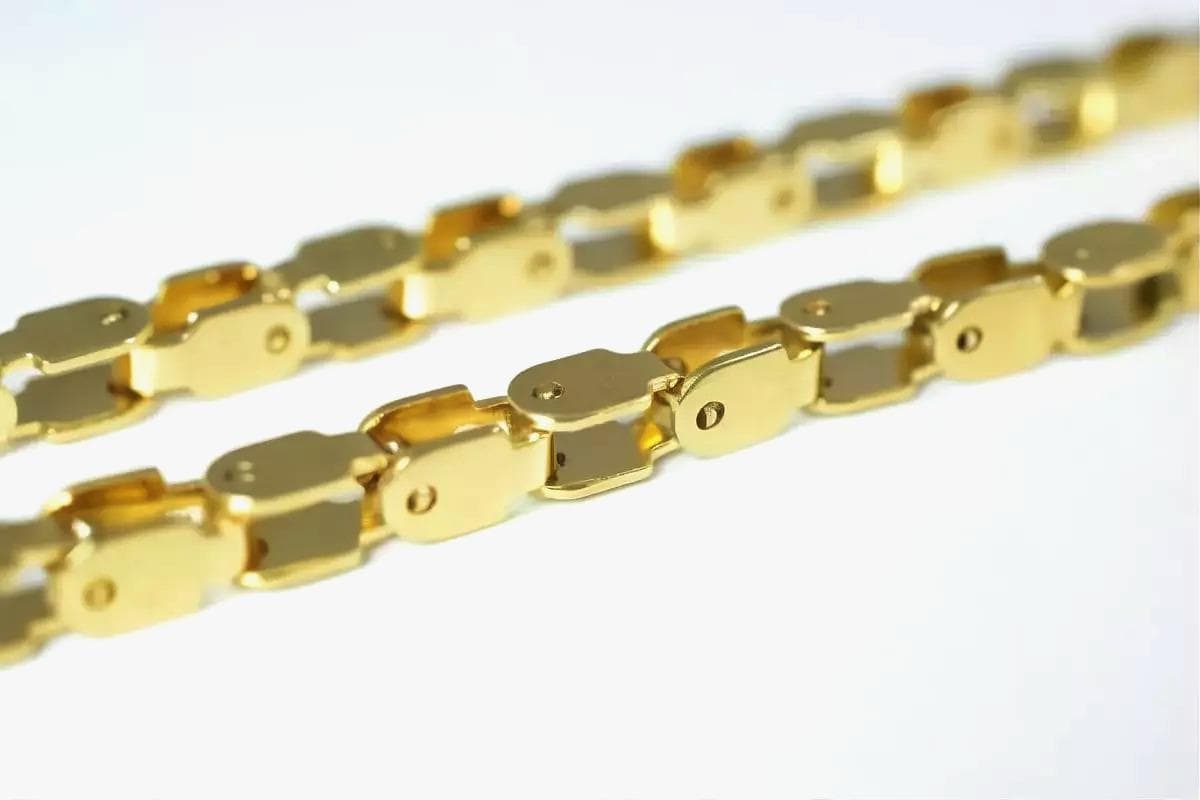 a close-up view of a gold chain with interlocking links, creating a shiny and metallic appearance.