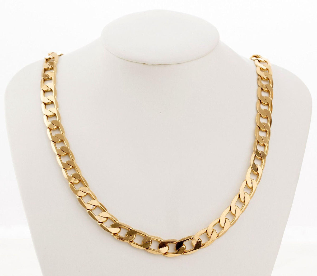 A gold chain necklace displayed on a white bust form.