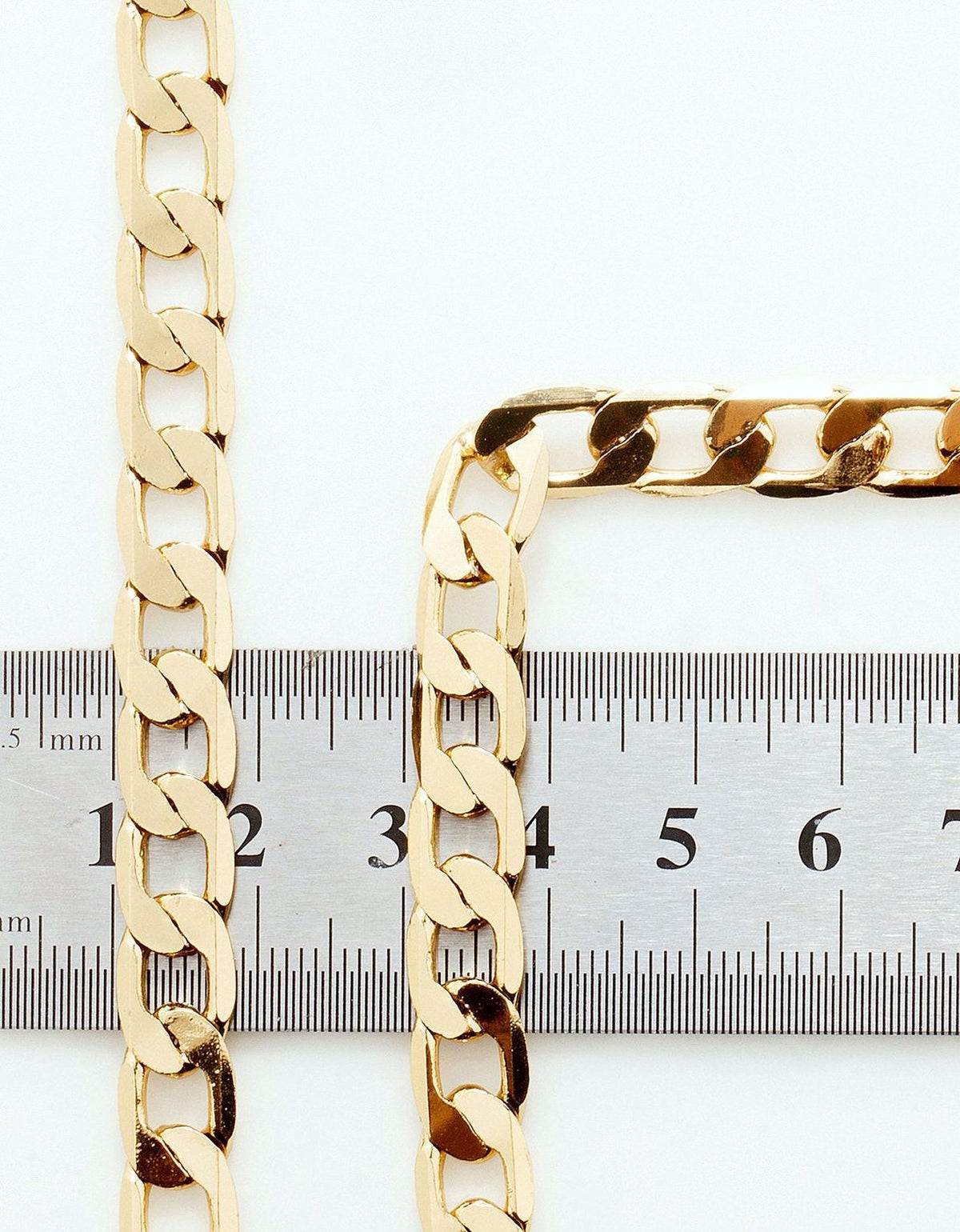 two gold chain necklaces placed next to a ruler for size comparison.