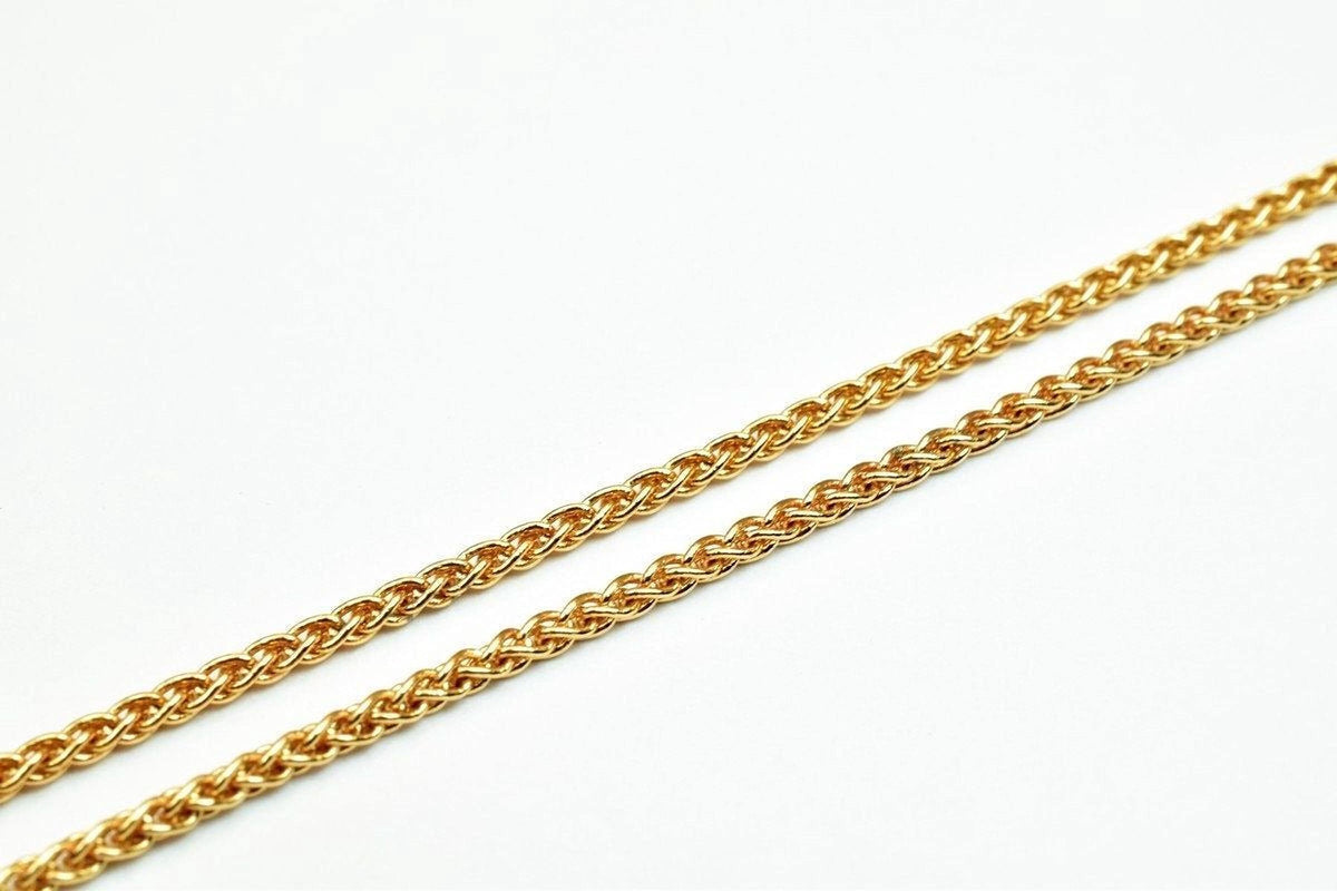 A close-up image of a gold chain necklace against a white background.