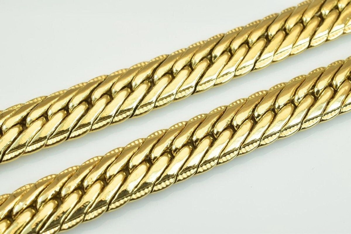 two gold-colored metal chains with a distinctive braided pattern.
