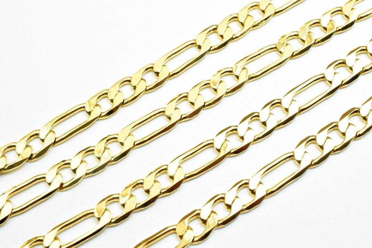 a close-up view of several gold-colored metal chain necklaces arranged in a row.