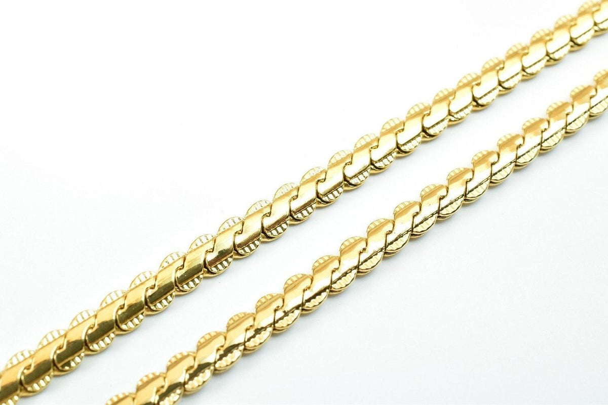 Two gold-colored necklaces with intricate designs are shown against a white background.