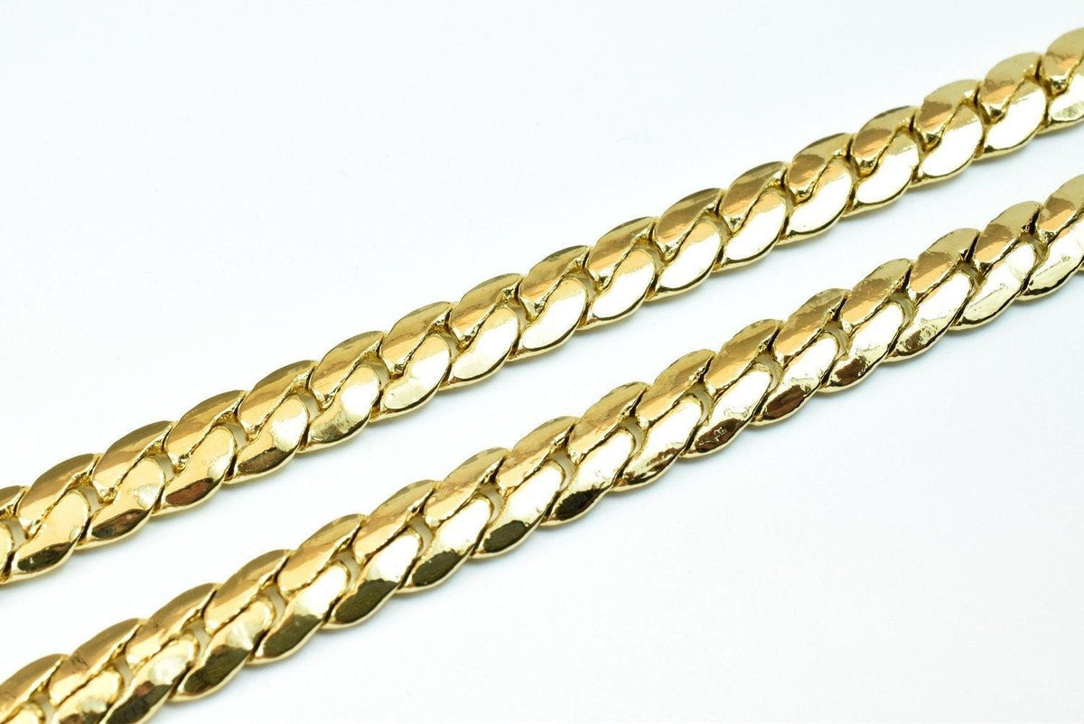 A close-up image of a gold chain necklace against a white background.