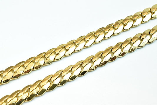 A close-up image of a gold chain necklace against a white background.