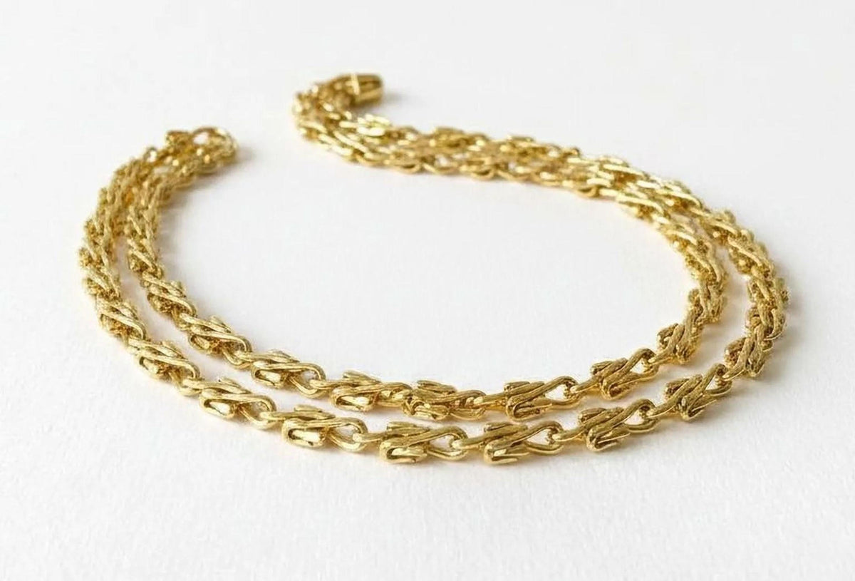 A gold chain necklace is shown against a white background.