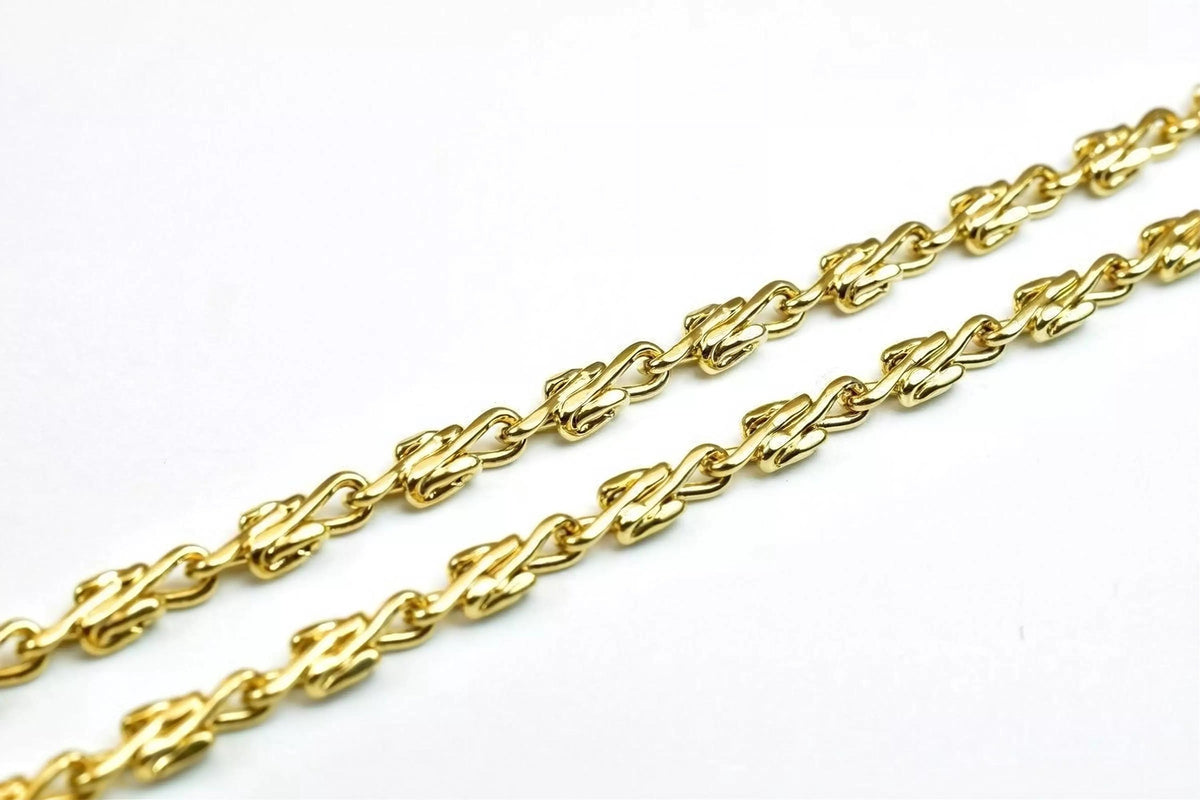 A close-up view of a gold chain with interlocking links, showcasing the intricate design and craftsmanship of the jewelry piece.