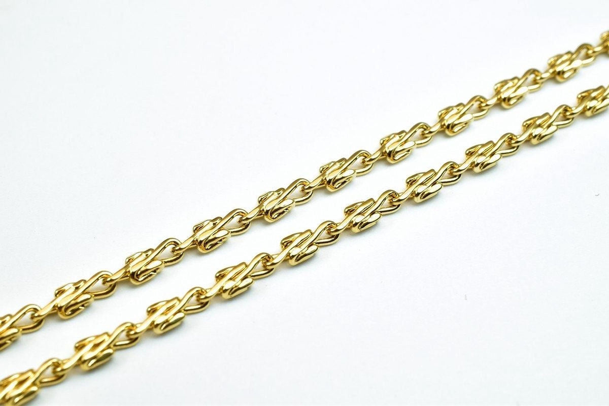 A close-up view of a gold chain necklace with multiple links arranged in a repeating pattern.
