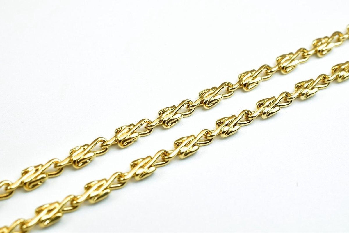 A close-up view of a gold chain with interlocking links, showcasing the intricate design and craftsmanship of the jewelry piece.