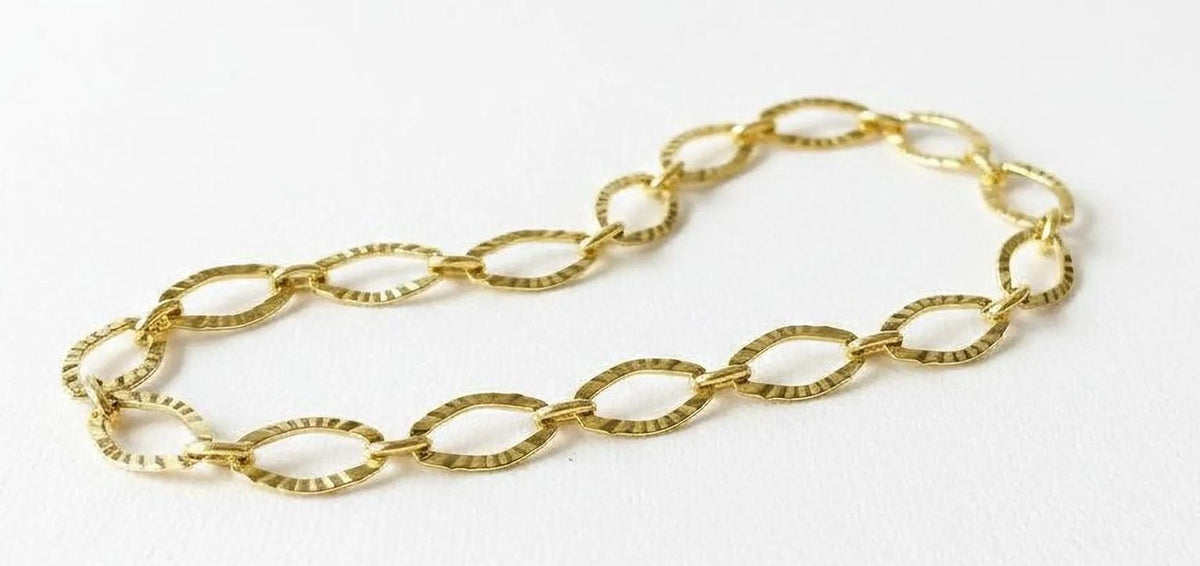 A gold chain bracelet is shown against a white background.