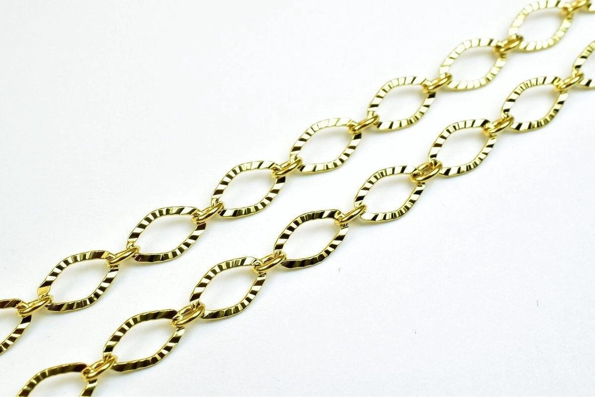 A close-up view of a gold-colored chain with interlocking links, creating a textured and shiny appearance.