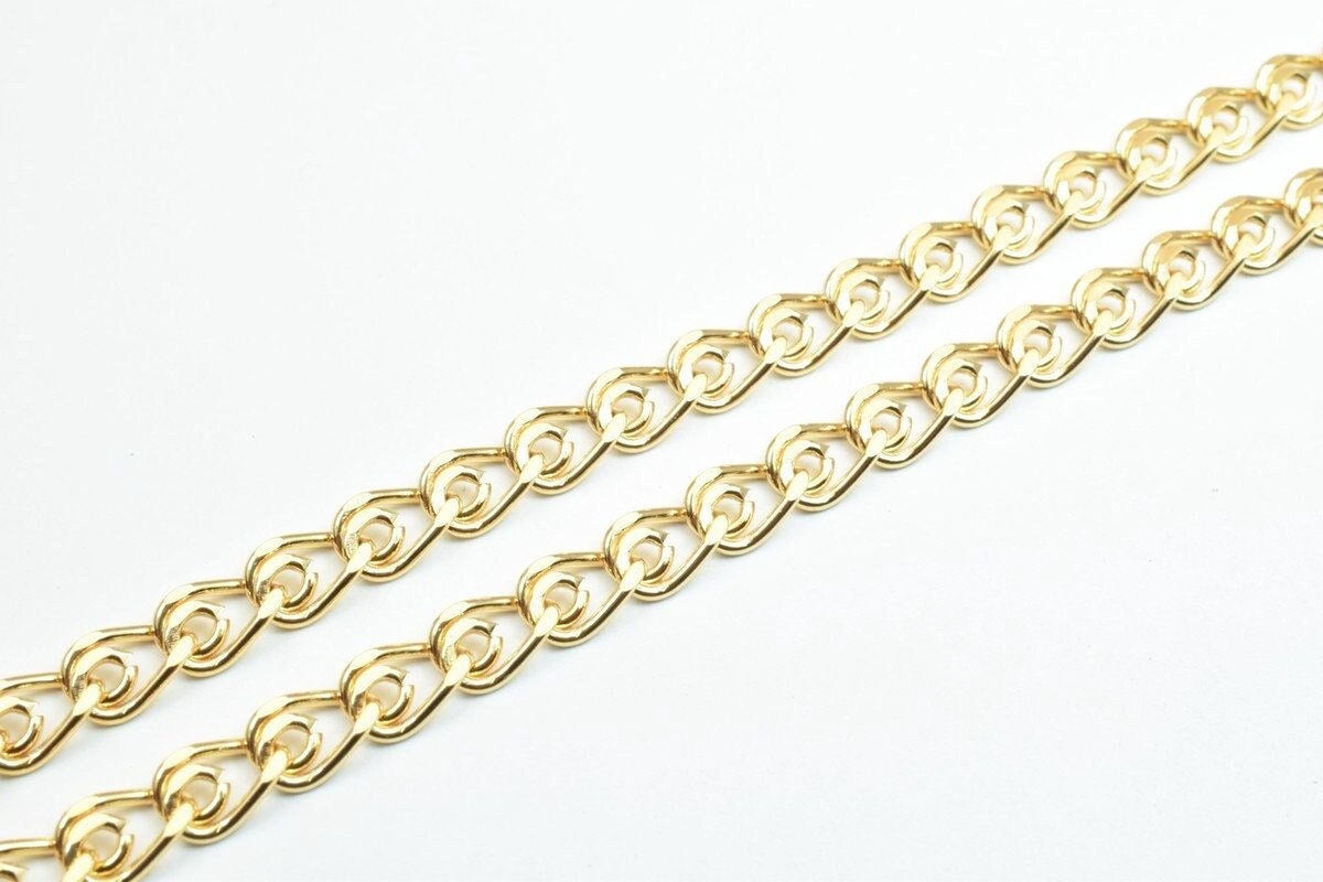 A close-up view of a gold-colored chain with interlocking links, arranged diagonally across a white background.