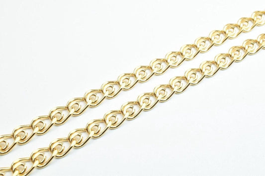 A close-up view of a gold-colored chain with interlocking links, arranged diagonally across a white background.