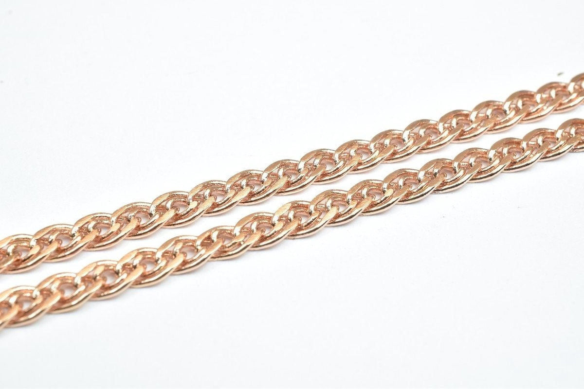 A close-up image of a chain made of small, interlocking links in a reddish-brown color.