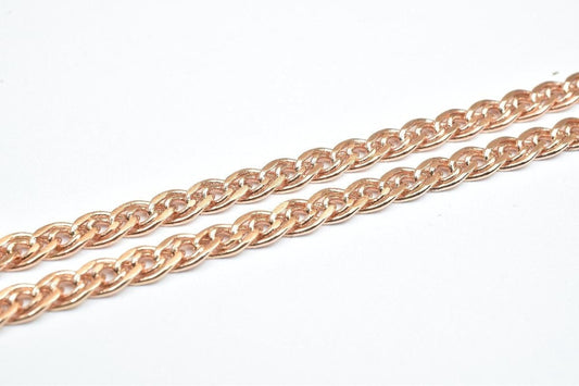 A close-up image of a chain made of small, interlocking links in a reddish-brown color.