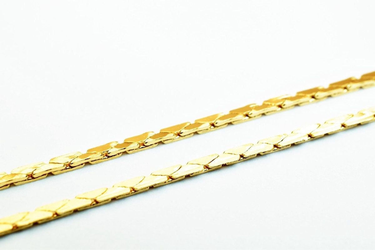 Two gold-colored metal chains with interlocking links are shown against a white background.