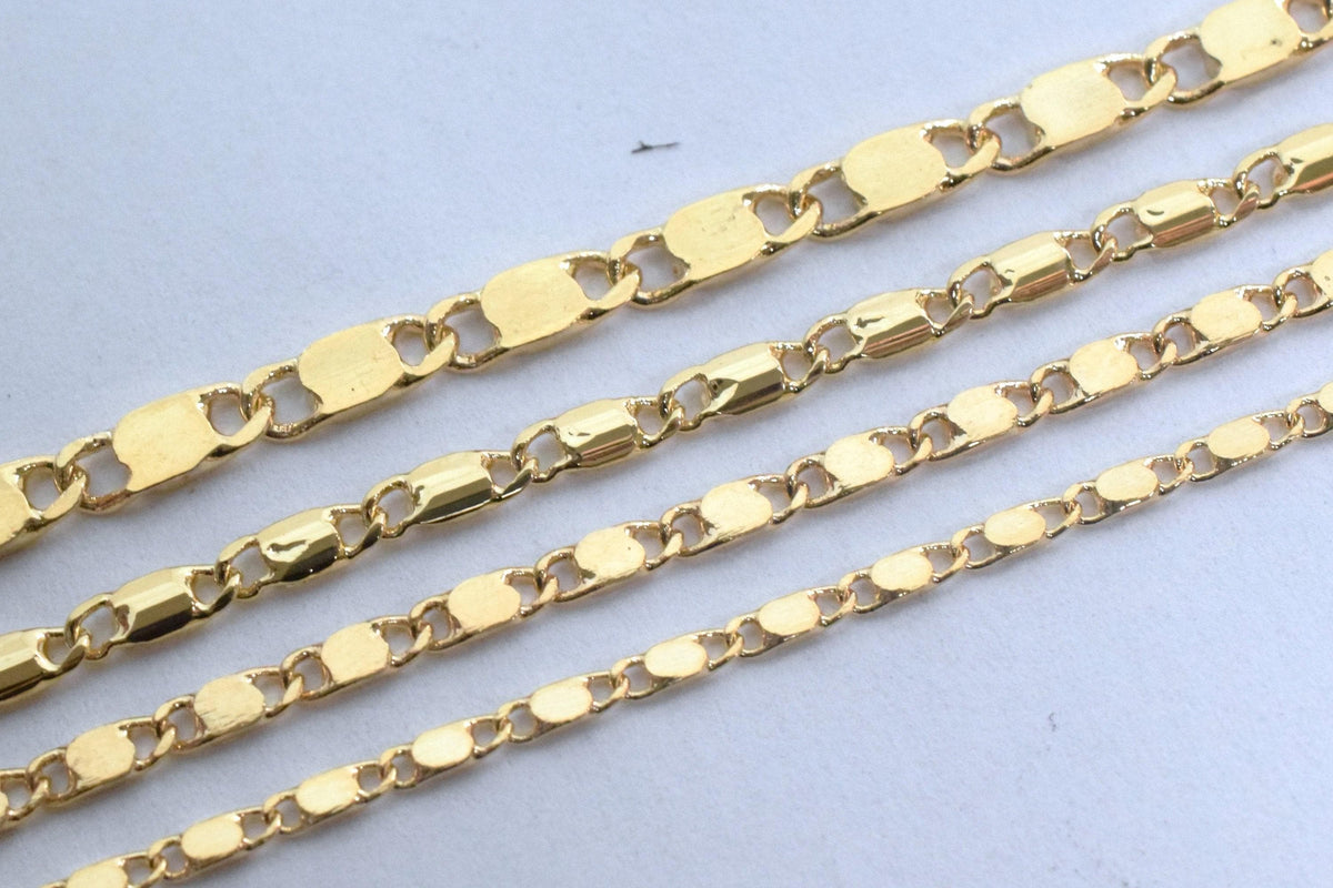 A close-up image of several gold-colored chain necklaces arranged in a row.