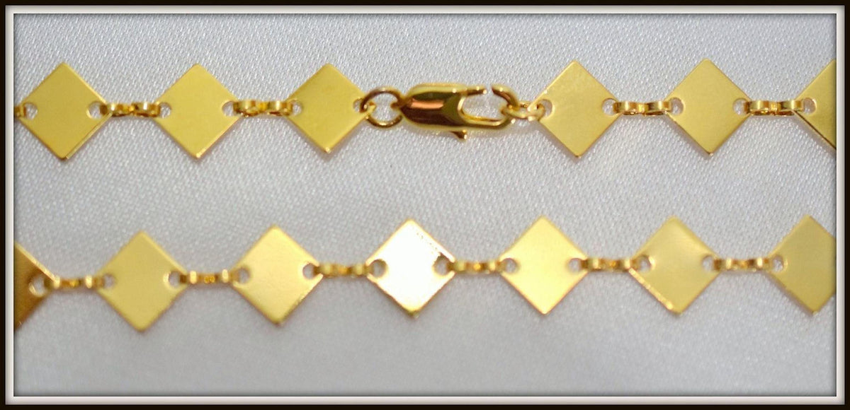 A close-up view of a gold-colored necklace with diamond-shaped links, showcasing the intricate design and craftsmanship of the piece.