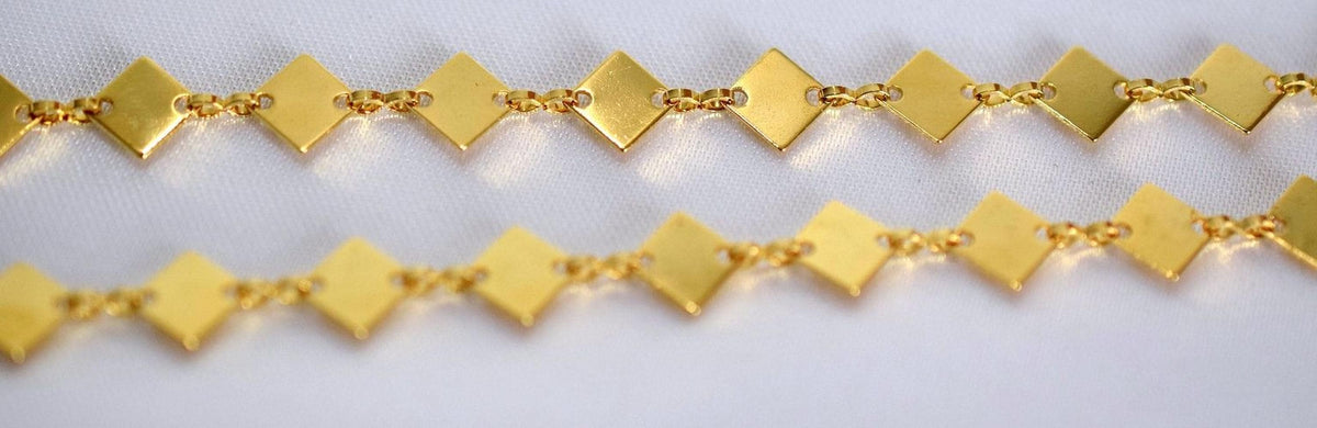a close-up view of a gold-colored chain with diamond-shaped links arranged in a repeating pattern.