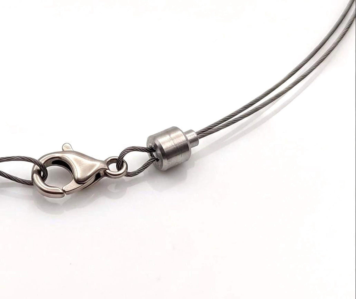 Silver stainless steel end locker crimp bead securing the cord end of a handmade metal collar bracelet.