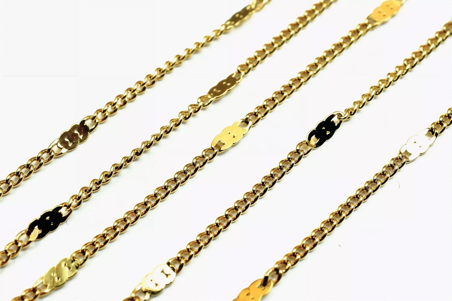 a collection of gold chain necklaces arranged in a row, with each necklace featuring a combination of gold and silver links.