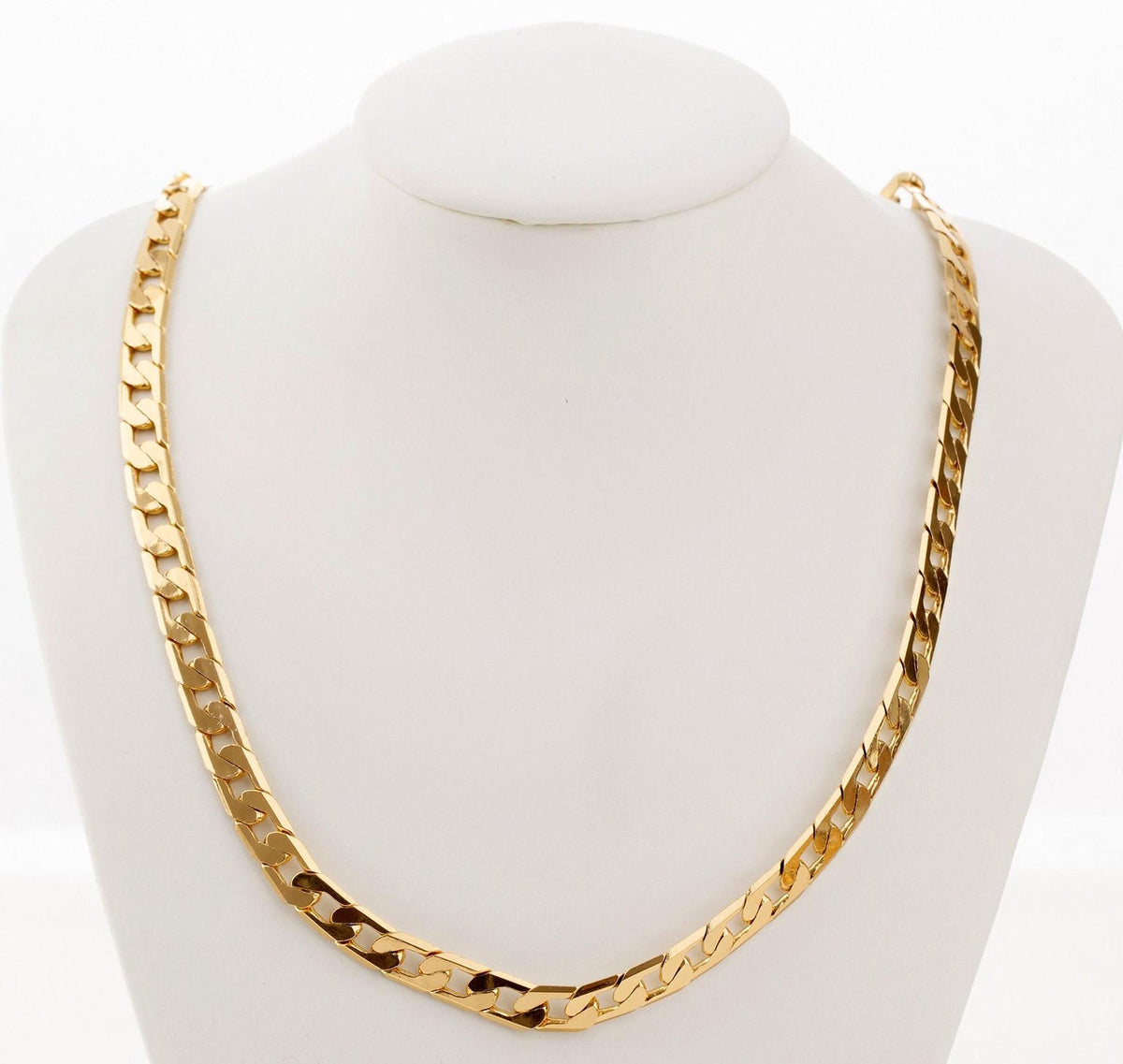 A gold chain necklace displayed on a white bust form.
