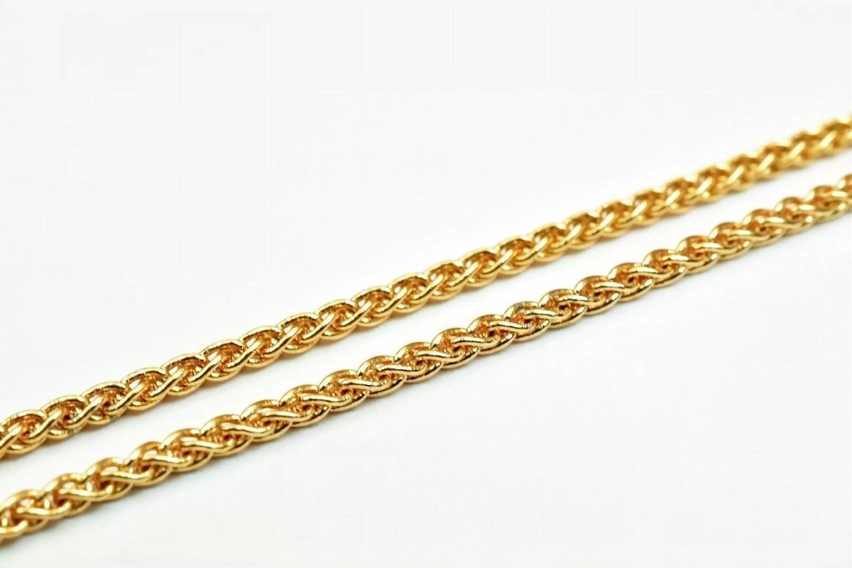 A close-up image of a gold chain necklace against a white background.