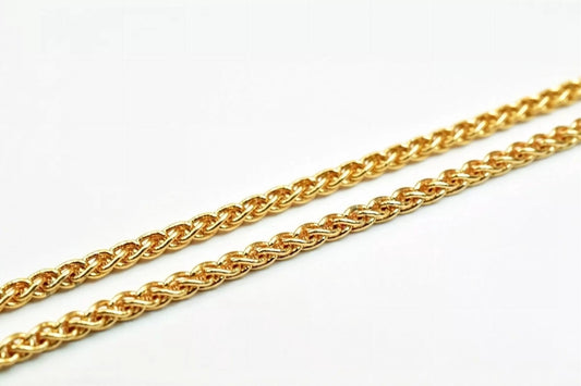 A close-up image of a gold chain necklace against a white background.