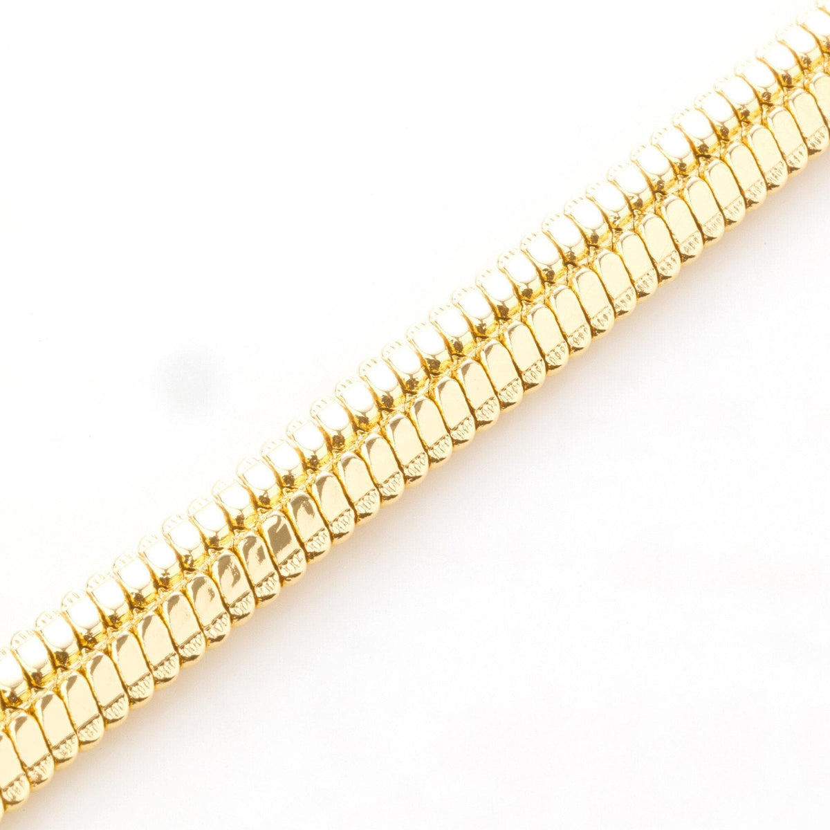 A gold chain with a repeating pattern of small, shiny, metallic links.