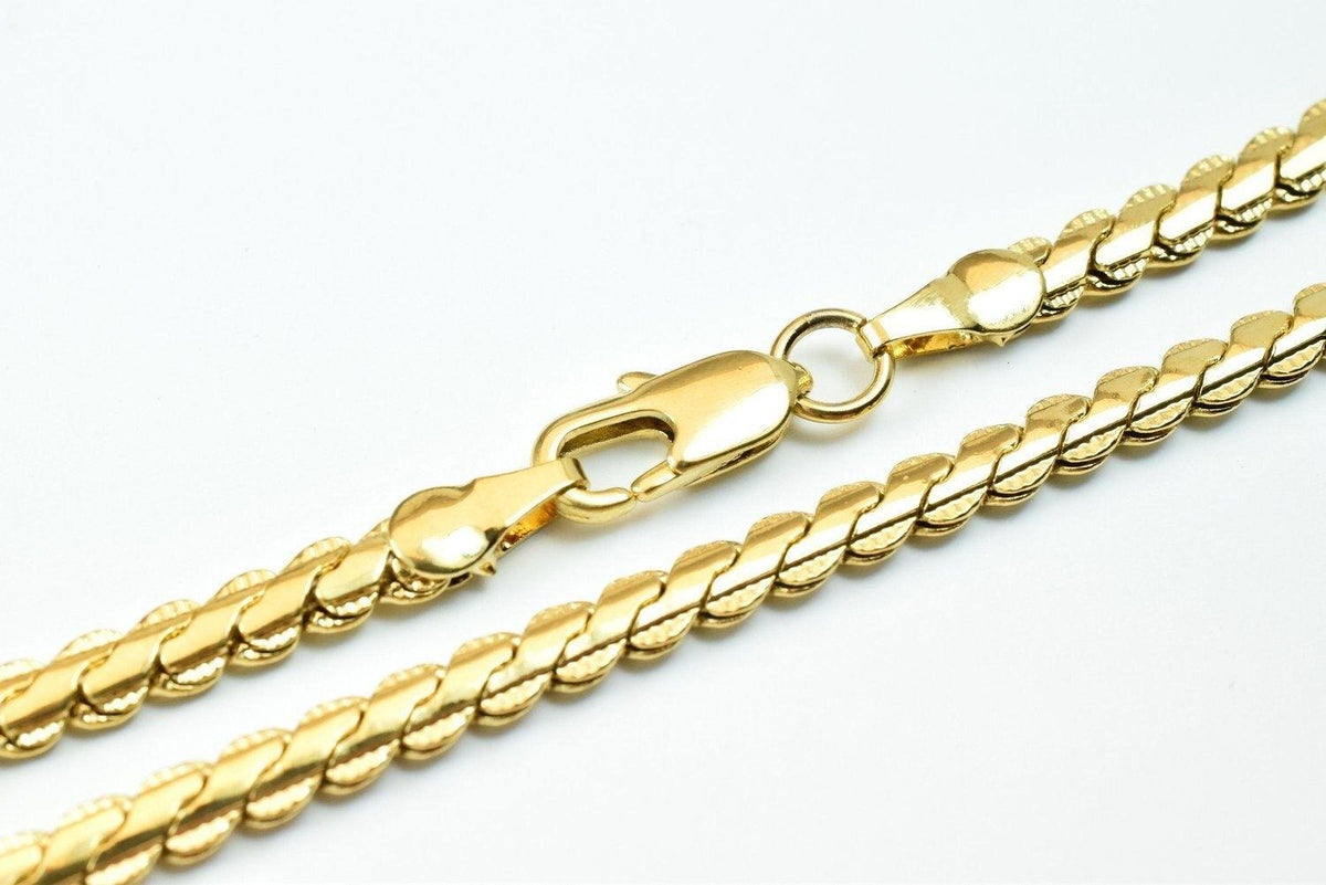 A close-up view of a gold chain necklace with a clasp and a clasp-like element.