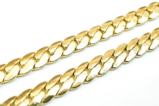 A close-up image of a gold chain necklace against a white background.