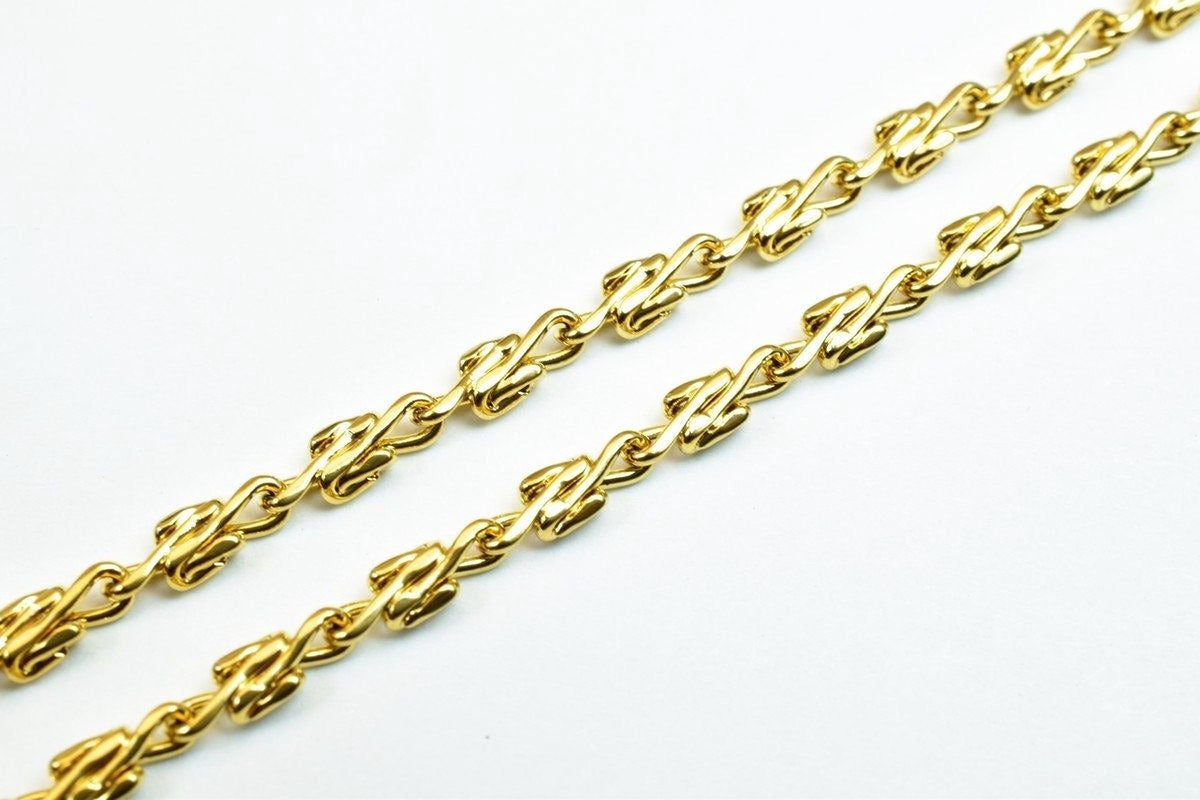 A close-up view of a gold chain with interlocking links, showcasing the intricate design and craftsmanship of the jewelry piece.