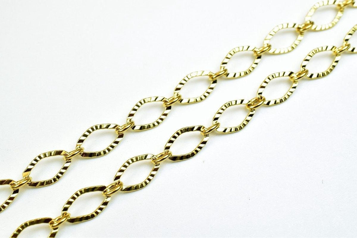 A close-up view of a gold-colored chain with interlocking links, creating a textured and intricate design.