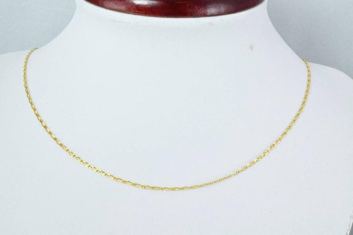 A gold chain necklace is displayed on a white mannequin.