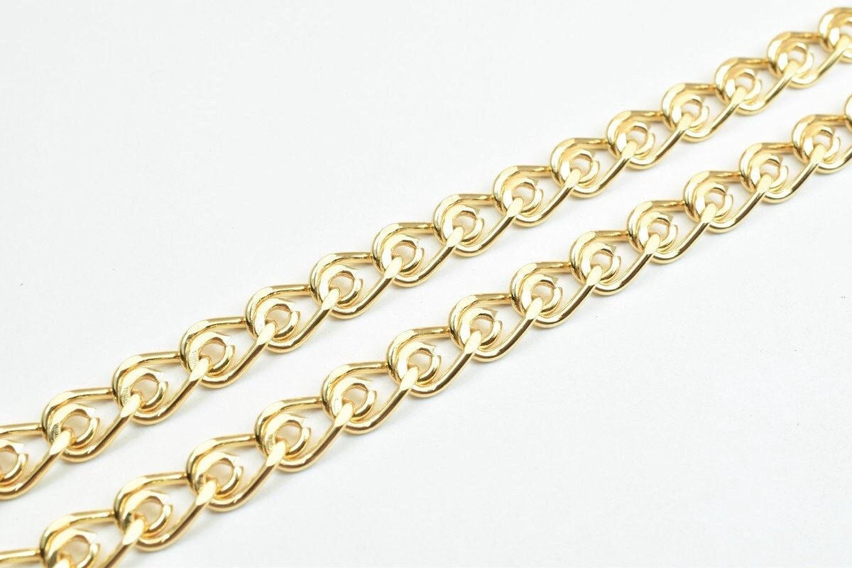 A close-up view of a gold-colored chain with interlocking links, arranged diagonally across a white background.