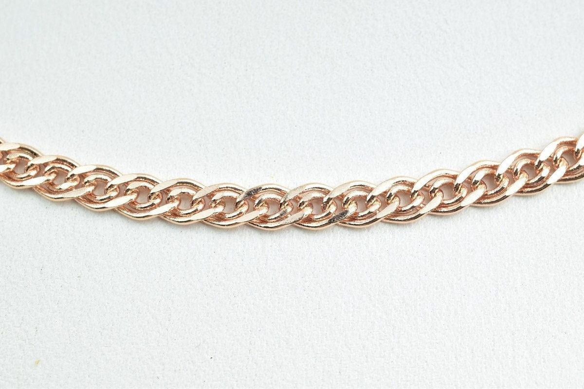 A close-up view of a delicate, gold-colored chain necklace against a plain white background.