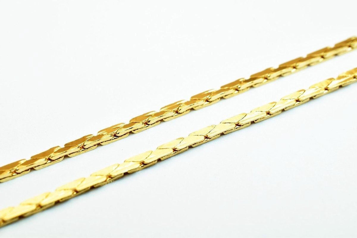Two gold-colored metal chains with interlocking links are shown against a white background.