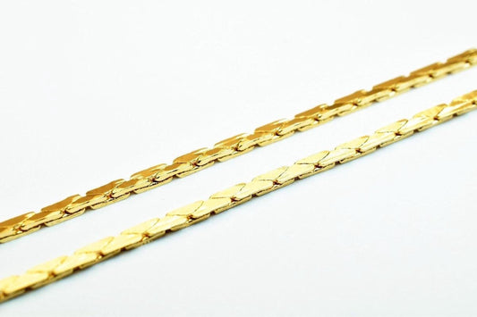 Two gold-colored metal chains with interlocking links are shown against a white background.