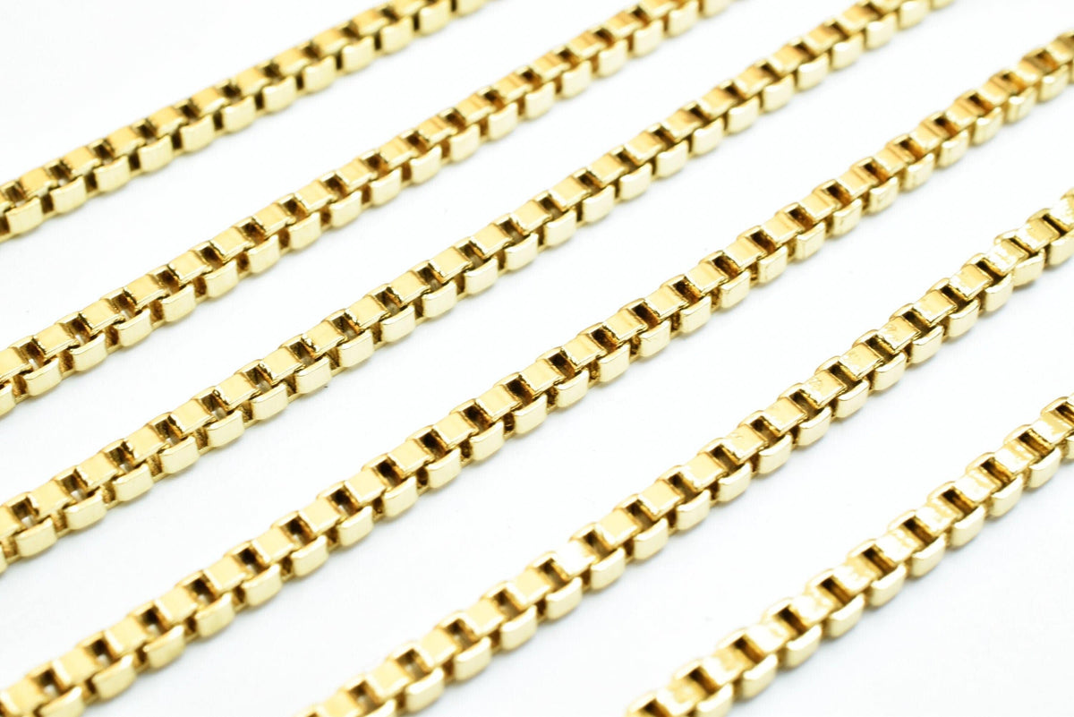 A close-up view of several gold-colored metal chains arranged in a repeating pattern.