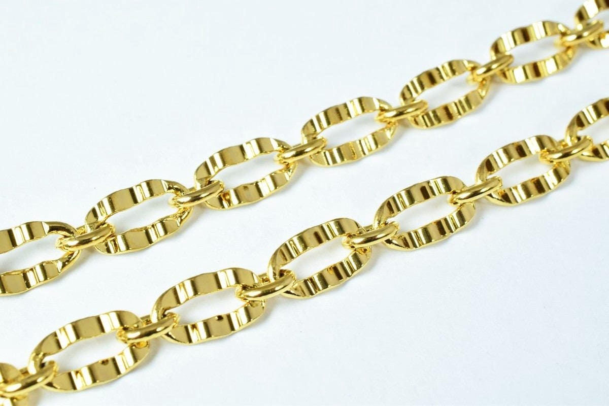 A close-up image of a gold chain with multiple links, showcasing the shiny and reflective surface of the gold material.