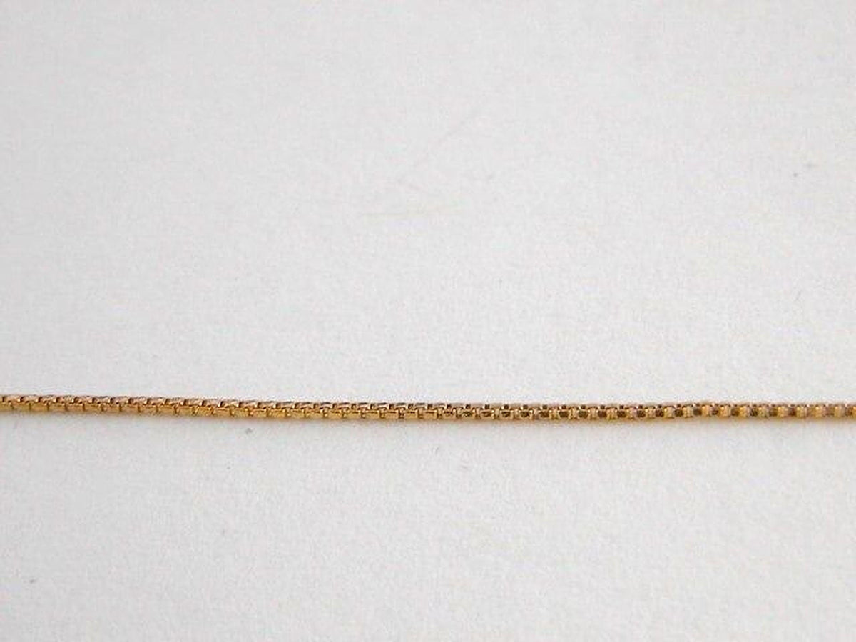 A gold chain necklace is shown against a plain white background.