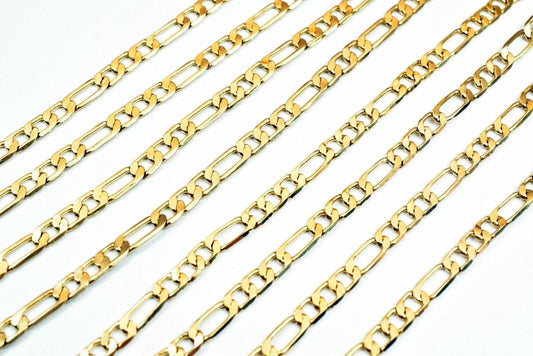A collection of gold-colored metal chain necklaces arranged in a diagonal pattern against a white background.