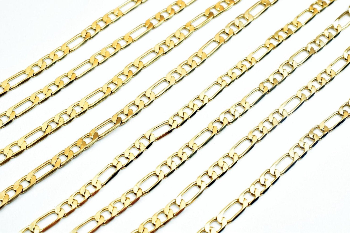 A collection of gold-colored metal chain necklaces arranged in a grid-like pattern against a white background.