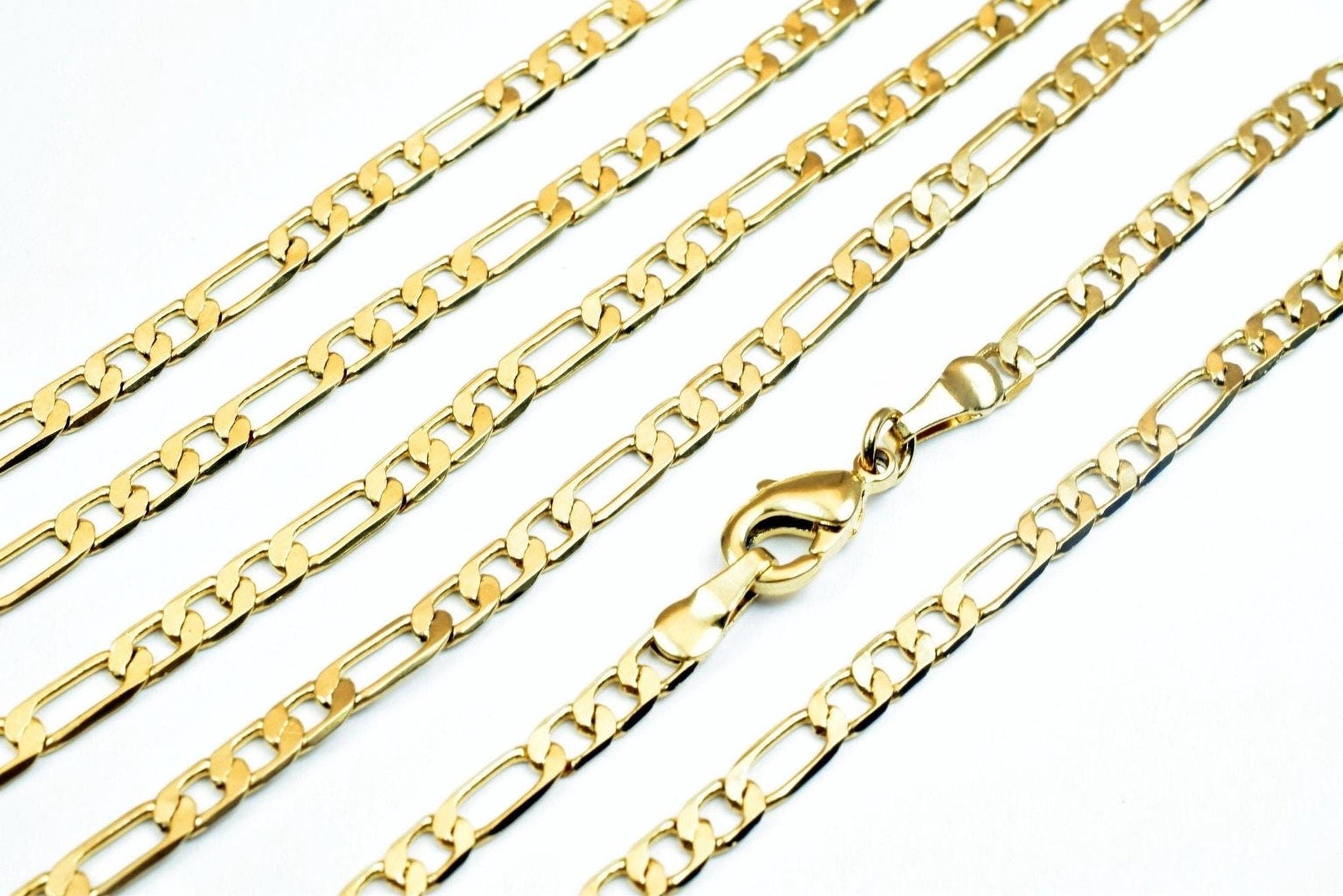 A close-up image of several gold-colored chain necklaces with a clasp visible.