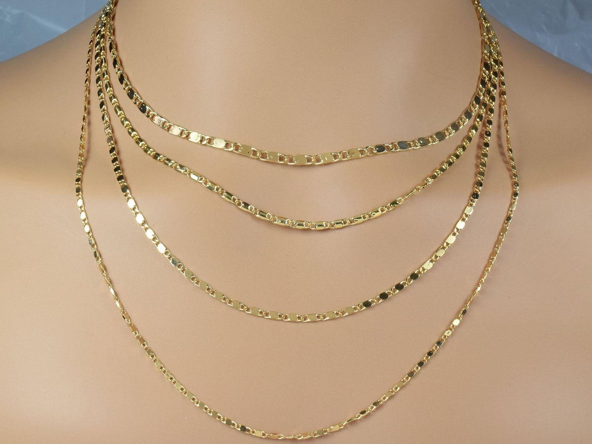 A close-up view of a gold necklace with multiple strands of chain, showcasing the intricate design and craftsmanship of the jewelry.