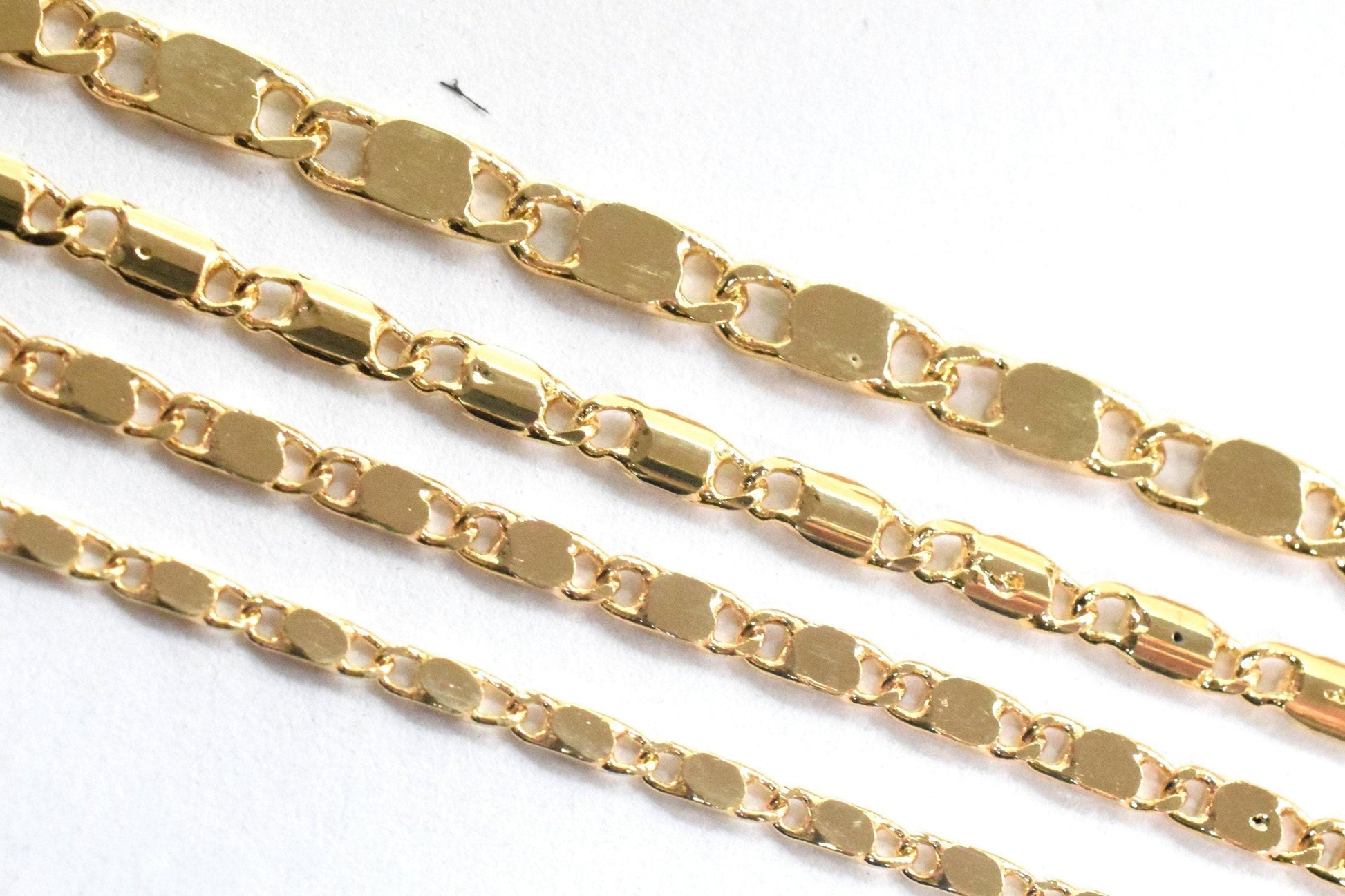 a close-up view of several gold-colored metal chains arranged in a row.