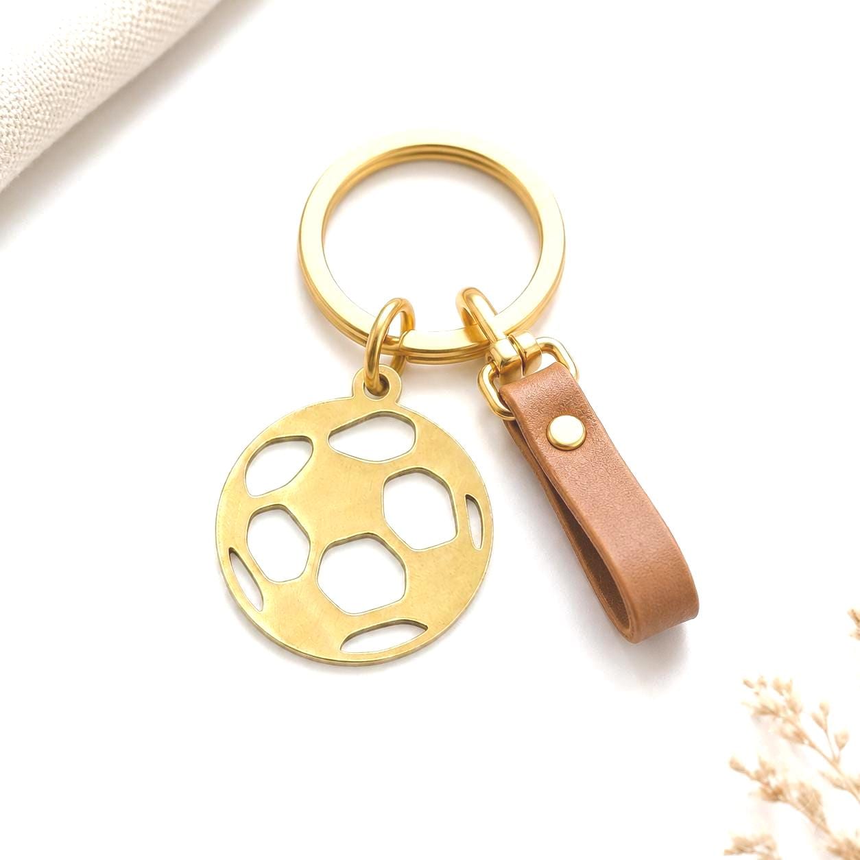 Round football charm with open cutout pattern and top loop